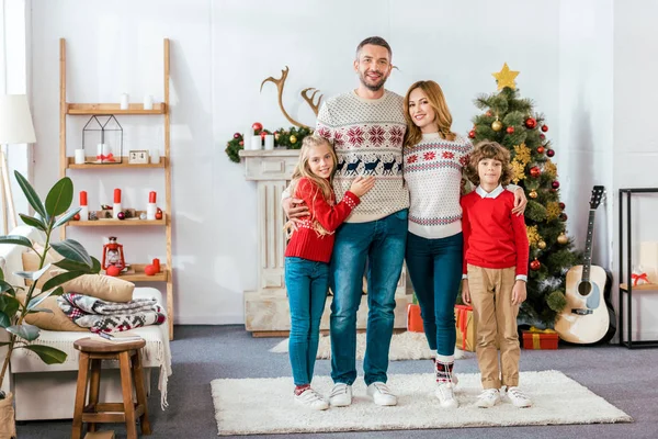 Szczęśliwy Młody Rodziny Ogarnięcie Boże Narodzenie Domu Patrząc Kamery — Zdjęcie stockowe