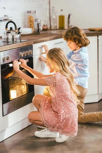 Λατρευτά Παιδιά Βλέπουν Ότι Ταψί Φούρνου Στην Κουζίνα — Φωτογραφία Αρχείου