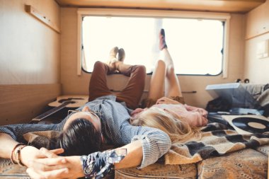 hippi çift içinde kamp aracına akustik gitar ve vinil oyuncu ile yalan