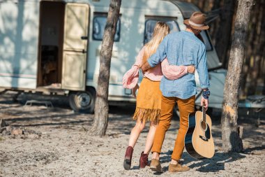 Dikiz sarılma ve römork yakınındaki gitar ile yürüme hippi çift