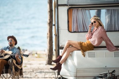 denize yakın gitar çalmak onun erkek arkadaşı ise kamp aracına üzerinde oturan hippi kız