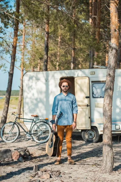 Man Houdt Van Akoestische Gitaar Permanent Trailer Met Fiets — Gratis stockfoto