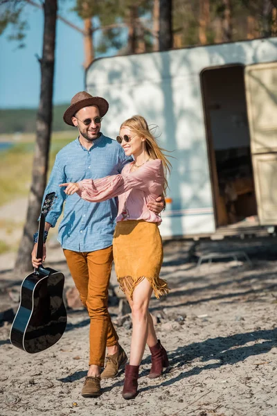 Young Hippie Couple Hugging Walking Guitar Campervan Girl Pointing Somewhere — Stock Photo, Image