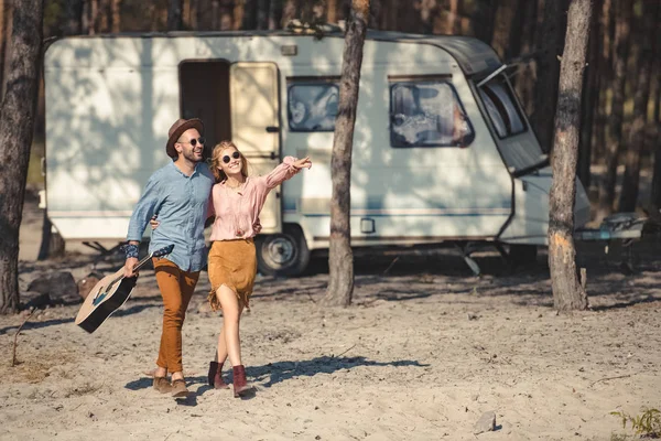 Jovem Casal Óculos Sol Abraçando Andando Com Guitarra Acústica Perto — Fotografia de Stock