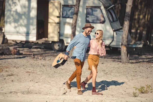 Hermosa Pareja Gafas Sol Abrazando Caminando Junto Con Guitarra Acústica — Foto de stock gratis