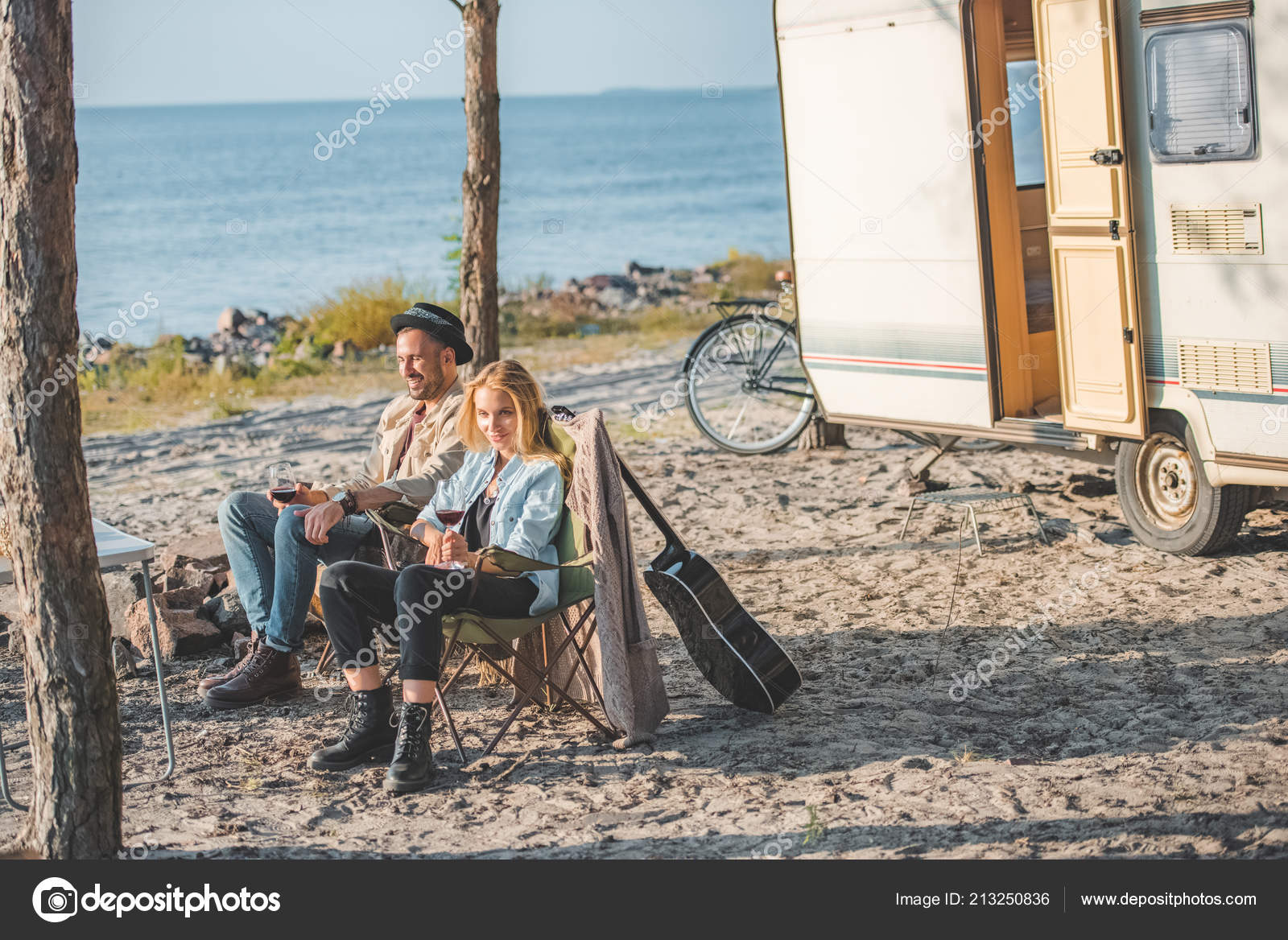 女の子とキャンピングカーの近くのピクニックの時に話してワインのグラスと彼氏 無料のストック写真 C Arturverkhovetskiy