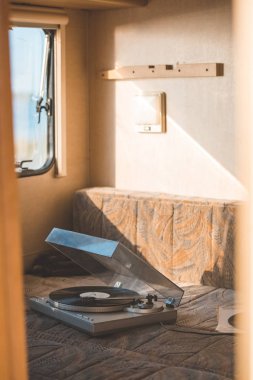 vintage vinyl player with record inside of campervan with sunlight clipart