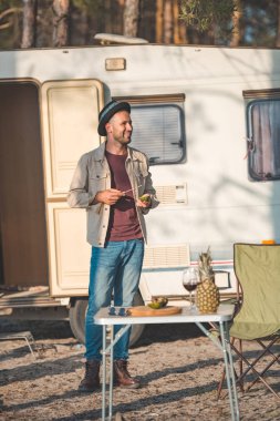 mutlu bir adam kesme avokado tablo şarap ve ananas, vanlife doğa ile yakın