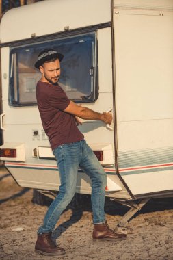 kamp aracına kapıyı açmaya çalışırken şapkalı yakışıklı adam