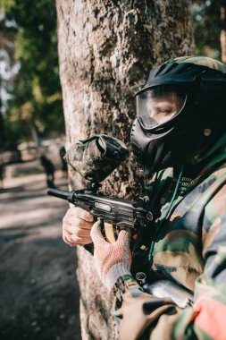 gözlüğü maskesi ve kamuflaj ile paintball silahı açık havada erkek paintball oyuncu 