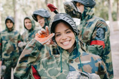 kamera onu takım ayakta açık havada arkasında ise tek tip bakarak içinde kadın paintballer gülen portre 