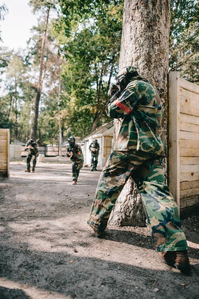 Baksikt Til Paintballspiller Kamuflasje Skyting Med Markørpistol Andre Lag Utendørs – royaltyfritt gratis stockfoto