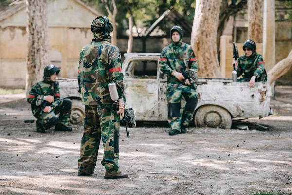 Paintball Team Kamuflażu Jednolite Guns Marker Odpoczynku Pobliżu Uszkodzonego Samochodu — Zdjęcie stockowe