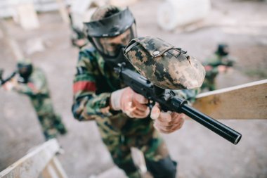 Merdiven açık havada çekim ekibi ise silahta marker tarafından hedefleyen erkek paintball oyuncu seçici odak 