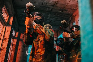 paintball takım tarafından terk edilmiş binada paintball tabancaları amaçlayan tek tip ve koruyucu maskeler düşük açılı görünüş