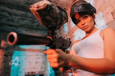 paintball silahı terk edilmiş binada tarafından baş amaçlayan yukarıda kamuflaj ve gözlüğü maskeli çekici kadın paintballer