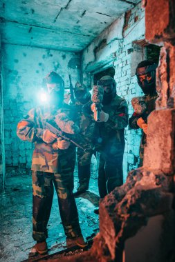 terk edilmiş binada paintball tabancaları ile düzgün ve koruyucu maskeler Paintball Takım
