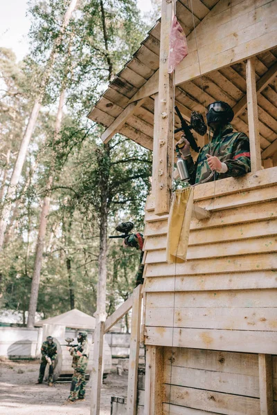 Vista Ángulo Bajo Del Jugador Paintball Torre Madera Quitando Bandera — Foto de stock gratis