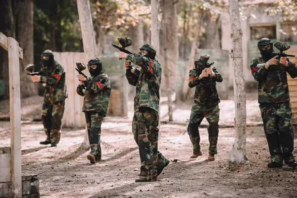 Tim Paintball Berseragam Dan Topeng Pelindung Menembak Dengan Senjata Paintball — Stok Foto