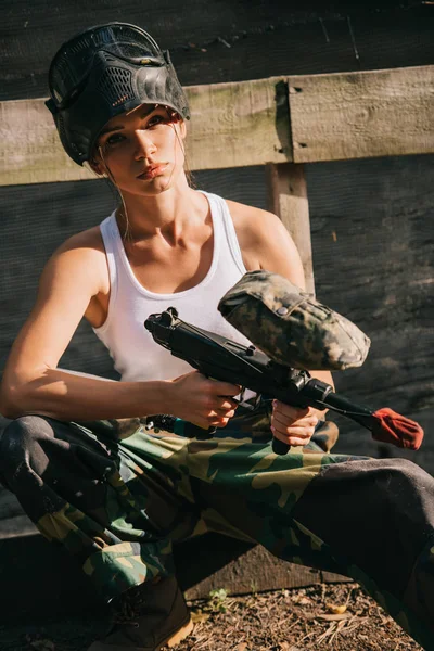 美丽的年轻女性 Paintballer 在白色单线和护目镜面具持有彩弹枪户外 — 免费的图库照片