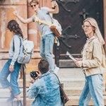 Giovani amici con mappa e macchina fotografica a piedi in città