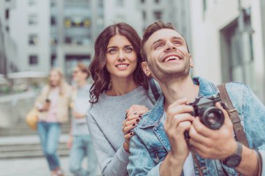turistler fotoğraf kamera arkadaşlarıyla şehirde tutarak birkaç gülümseyen