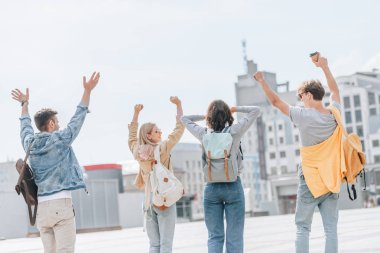 arkadan görünüşü eller genç şık turistler eğleniyor ve şehirde yürüyüş 