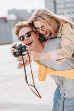 o fotoğrafta fotoğraf makinesinde iken güzel kız arkadaşım sırtıma veren erkek gülümseyen