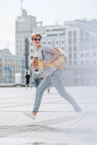 Elegante Uomo Allegro Con Caffè Andare Zaino Piedi Sulla Strada — Foto stock gratuita