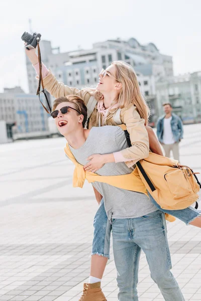 Excited Boyfriend Piggybacking Girlfriend While She Taking Photo Camera — Stock Photo, Image