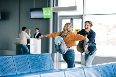 Havaalanı terminal sarılma sırt çantaları ile mutlu genç çift  