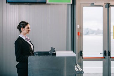 check-masası havaalanında, güzel genç bir kadın işçi yan görünüm