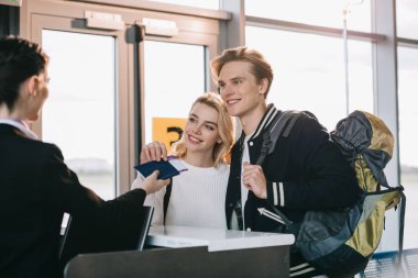 happy young couple at check-in desk in airport  clipart
