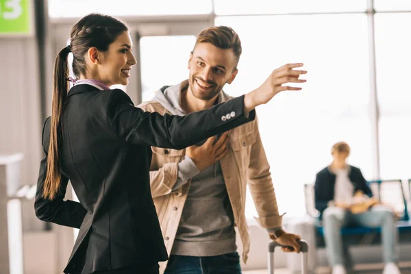 Sorrindo Jovem Trabalhador Aeroporto Mostrando Caminho Para Viajante Feliz — Fotografia de Stock