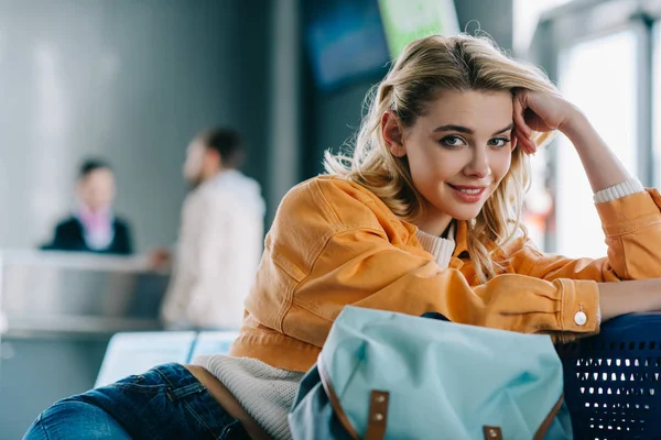 Mooie Jonge Vrouw Met Rugzak Glimlachend Camera Zittend Luchthaventerminal — Stockfoto