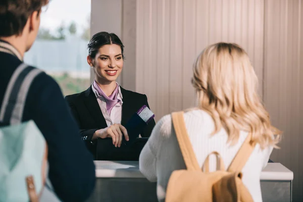 Achteraanzicht Van Jonge Paar Kijken Glimlachend Luchthaven Werknemer Bij Check — Stockfoto