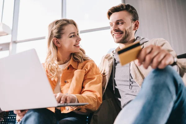 Hombre Sonriente Sosteniendo Tarjeta Crédito Mujer Joven Usando Ordenador Portátil —  Fotos de Stock