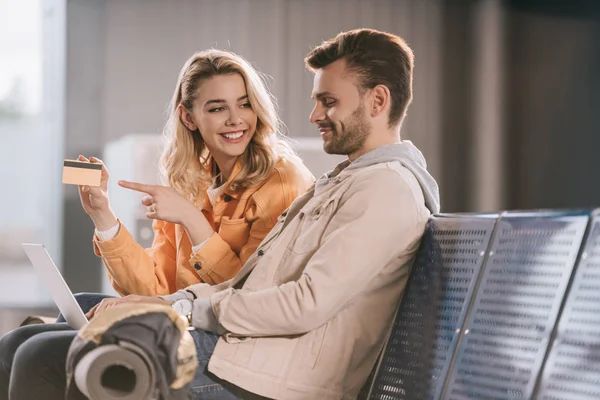 Sonriente Mujer Joven Señalando Con Dedo Tarjeta Crédito Mirando Hombre — Foto de Stock