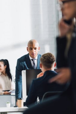 ofiste iş arkadaşı ile konuşurken ciddi genç Afro-Amerikalı iş adamı