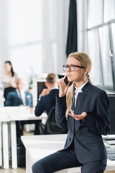 Serious Young Businesswoman Talking Smartphone Looking Away Office — Free Stock Photo