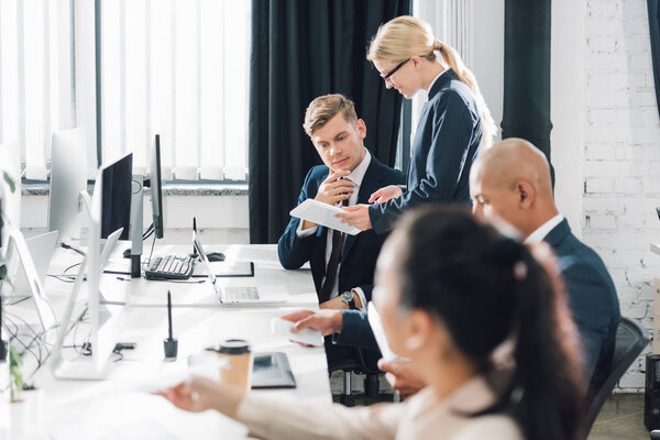 молодые мультиэтнические бизнесмены, работающие с цифровыми устройствами в открытом космосе
