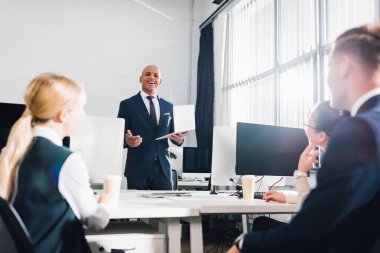 düşük açılı görünümü Office arkadaşları bakarak gülümseyen genç Afro-Amerikalı iş adamı 