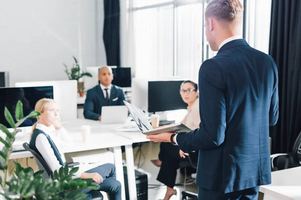 Back View Young Businessman Holding Laptop Talking Colleagues Office — Stock Photo, Image