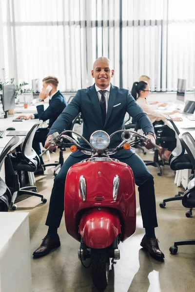 Happy Young African American Businessman Riding Red Scooter Smiling Camera — Free Stock Photo