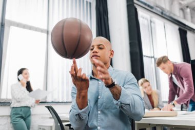 Afrika kökenli Amerikalı gencin basketbol topu Office ile oynarken düşük açılı görünüş 
