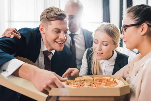 Sorrindo Jovens Colegas Trabalho Olhando Para Pizza Saborosa Escritório — Fotografia de Stock