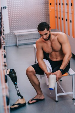 Yüzme Havuzu, soyunma, bankta oturmuş yapay bacak kas genç sporcu