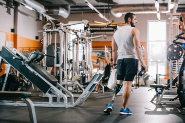 yakışıklı genç sporcu spor salonunda duran ve havlu tutan yapay bacak ile