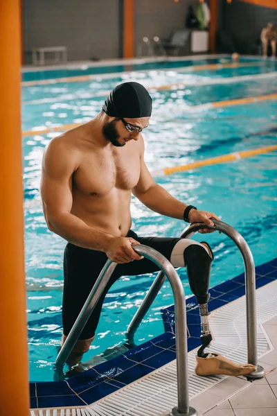 有人工腿的肌肉发达的年轻游泳运动员从游泳池里出来 — 图库照片