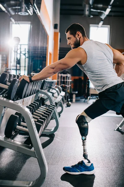 yapay bacak dumbbell vasıl jimnastik salonu ile çalışma dışarı ile genç sporcu yan görünüm